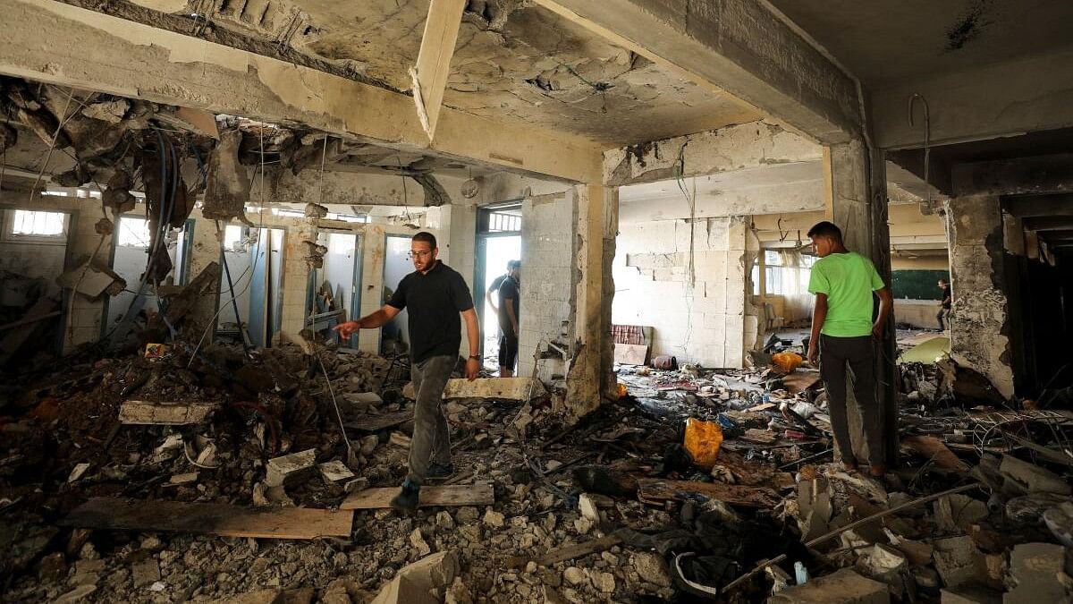 <div class="paragraphs"><p>Palestinians inspect a school after it was hit by an Israeli strike, in Gaza City.</p></div>