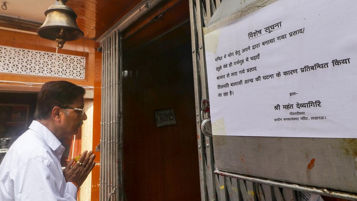 <div class="paragraphs"><p>A devotee offers a prayers as a notice pasted by the management at the Mankameshwar Mandir asking devotees to bring their own 'prasad' amid controversy over animal fat inclusion in 'laddus' at Tirupati Balaji temple, in Lucknow.</p></div>