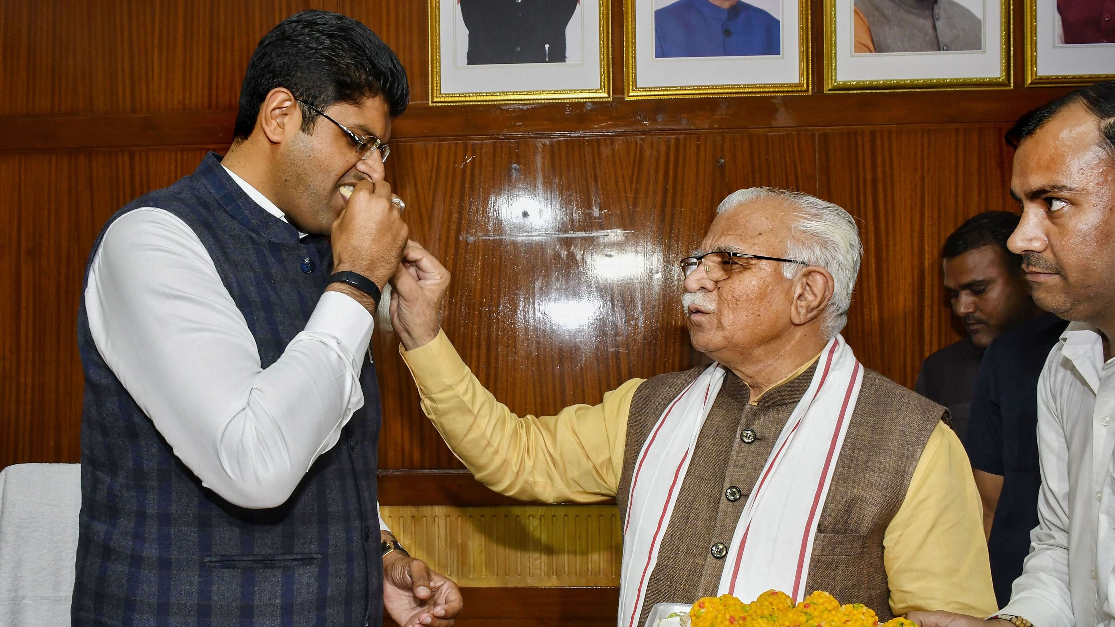 <div class="paragraphs"><p>File photo of former Haryana Chief Minister Manohar Lal offering&nbsp;sweets to former Deputy Chief Minister and JJP chief Dushyant Chautala</p></div>