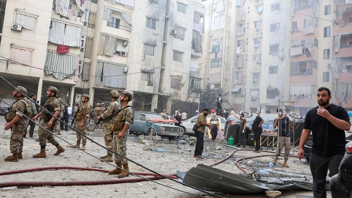 <div class="paragraphs"><p>People and members of the military inspect the site of an Israeli strike in the southern suburbs of Beirut, Lebanon.</p></div>