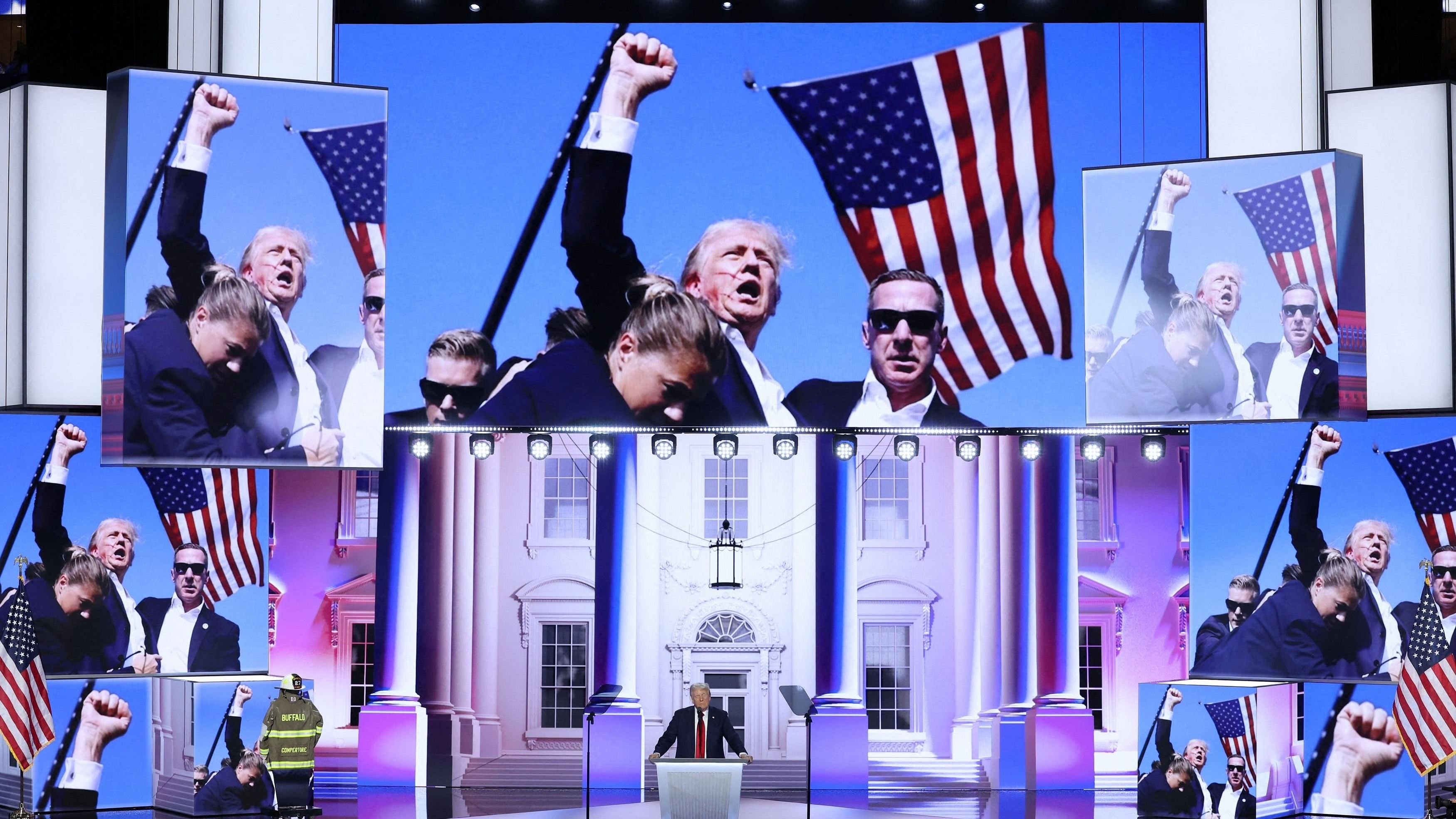 <div class="paragraphs"><p>Republican presidential nominee and former US President Donald Trump takes the stage as the firefighter's turnout coat and helmet belonging to former Buffalo Township Volunteer Fire Department chief Corey Comperatore, who was killed at his rally, is shown along with an image taken by photographer Evan Vucci after the assassination attempt on his life as he gives his acceptance speech on Day 4 of the Republican National Convention.</p></div>