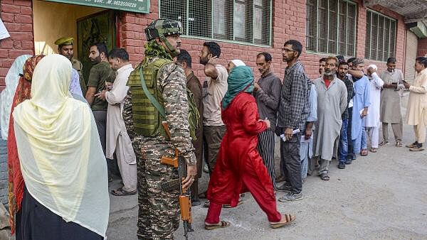 <div class="paragraphs"><p>Voters stand in a queue to cast votes at a polling station during the second phase of Jammu and Kashmir Assembly elections, in Srinagar</p></div>