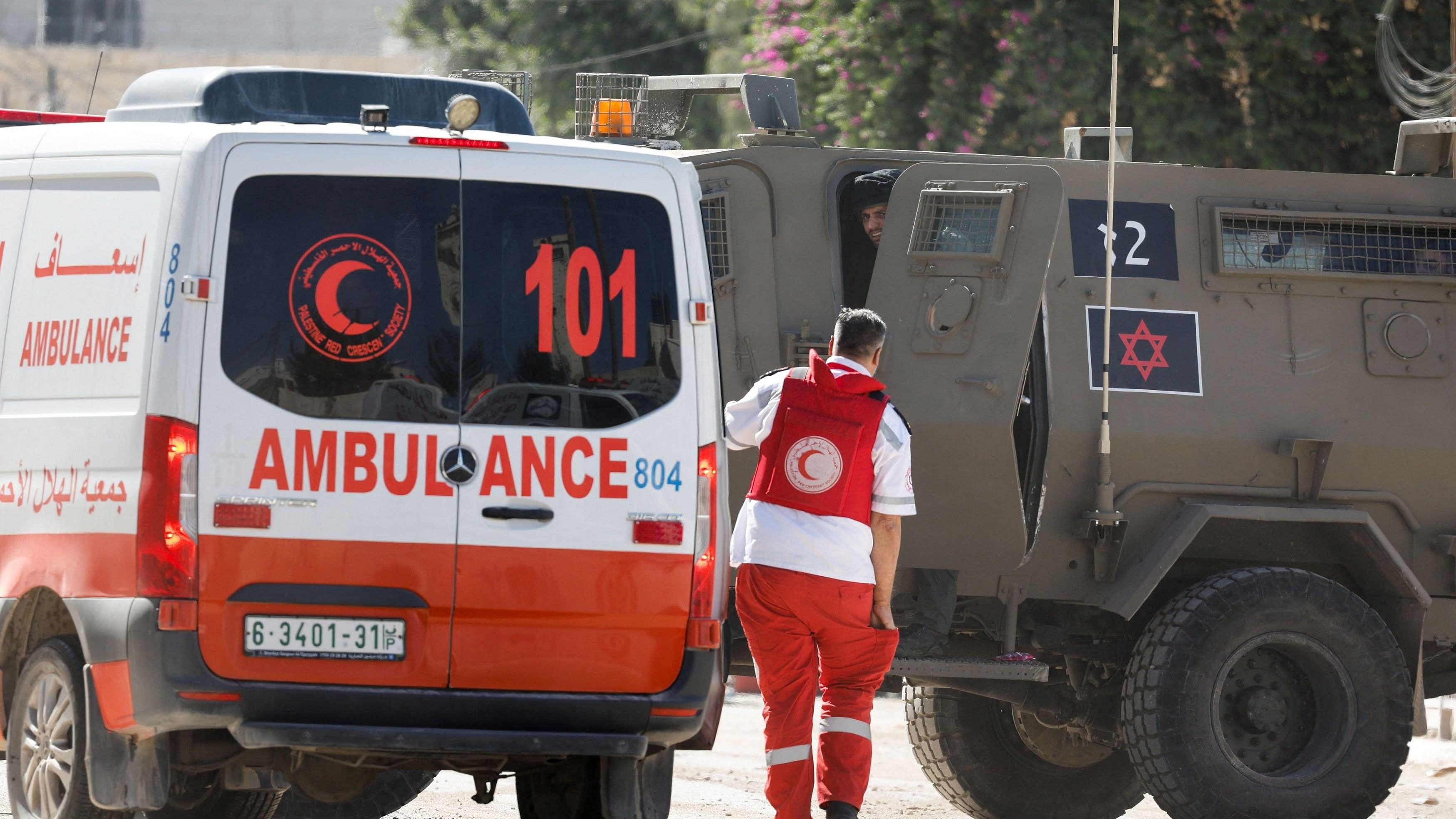 <div class="paragraphs"><p>A member of the Palestine Red Crescent Society  walks near an ambulance and Israeli military vehicle, during a raid, in Jenin, in the Israeli-occupied West Bank, August 28, 2024. </p></div>