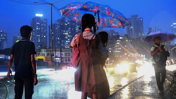 <div class="paragraphs"><p>Two school students share an umbrella to shield themselves during rain, in Mumbai.</p></div>