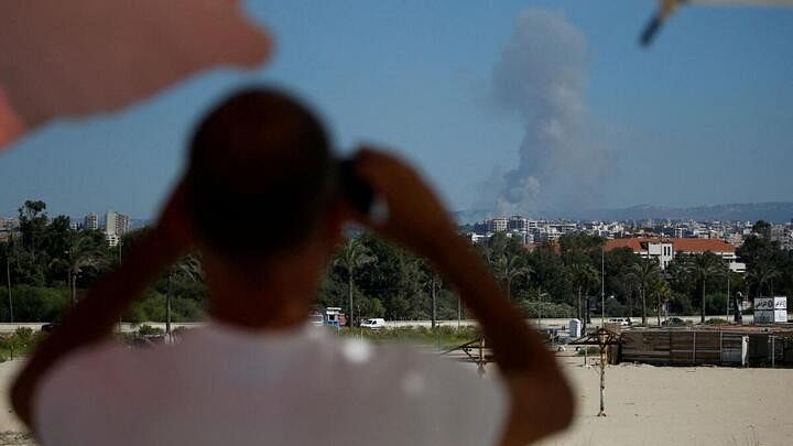 <div class="paragraphs"><p>A man watches as smoke billows over southern Lebanon following an Israeli strike, amid ongoing cross-border hostilities between Hezbollah and Israeli force.</p></div>