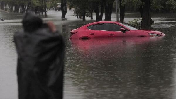 <div class="paragraphs"><p>A man takes a photo of a car partially submerged on a flooded street during Tropical Storm John, in Lazaro Cardenas, Michoacan state, Mexico, September 27, 2024.</p></div>