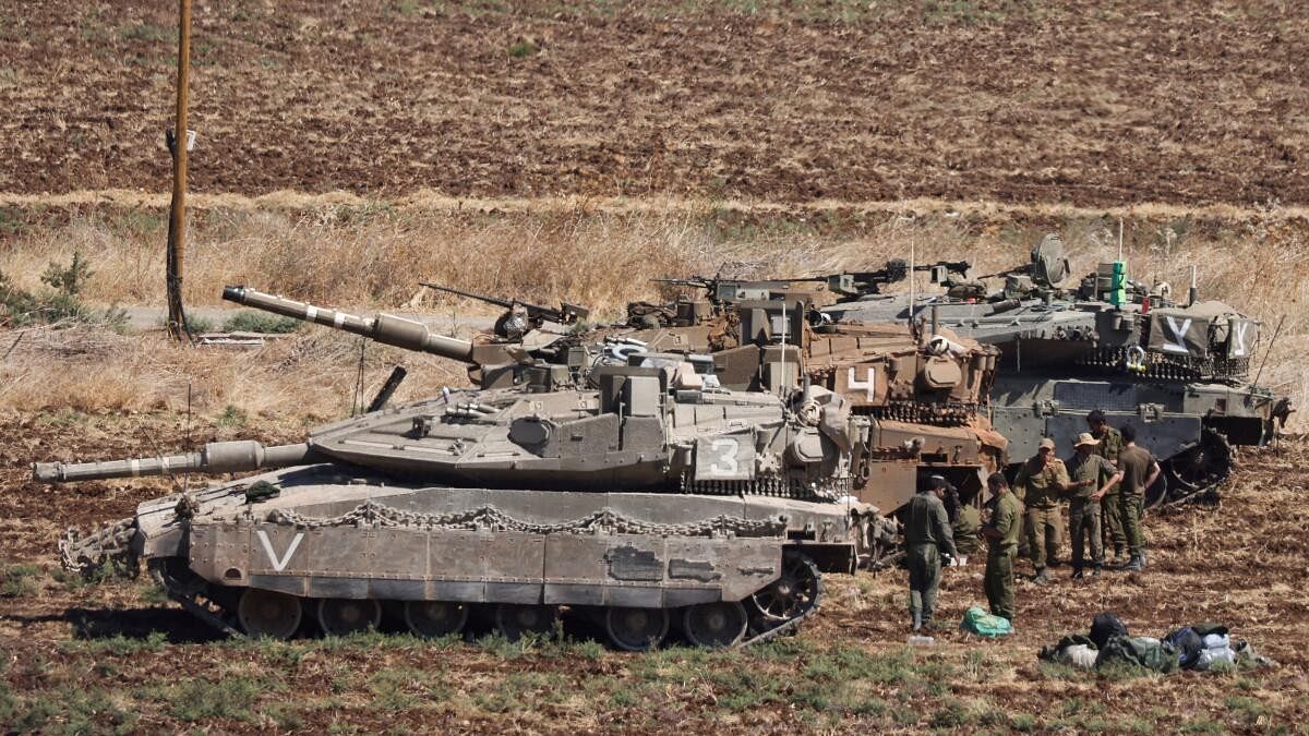 <div class="paragraphs"><p>People stand next to Israeli Army tanks, amid cross-border hostilities between Hezbollah and Israel, in northern Israel,</p></div>