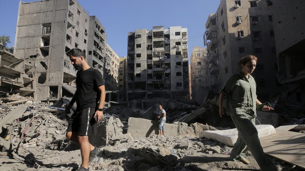 <div class="paragraphs"><p>People walk on the rubble at the site of the Israeli airstrike that killed Lebanon's Hezbollah leader Sayyed Hassan Nasrallah on Friday, in Beirut's southern suburbs.</p></div>