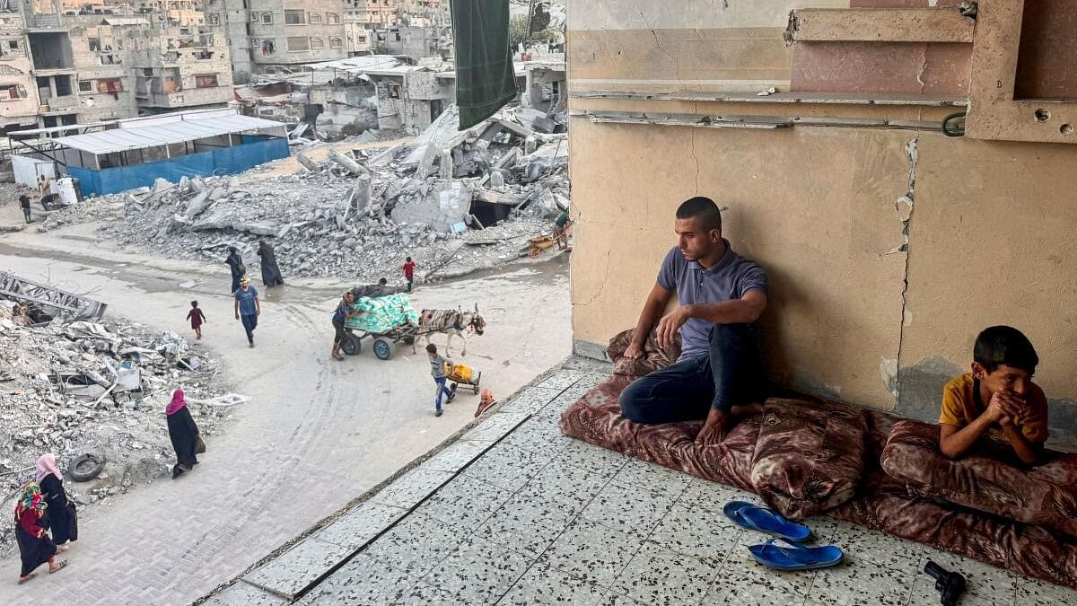 <div class="paragraphs"><p>Palestinians rest near rubble of houses destroyed in Israeli strikes,.</p></div>