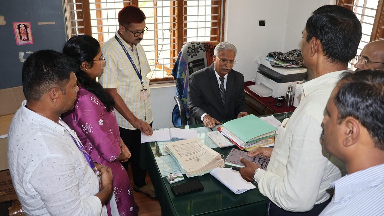 <div class="paragraphs"><p>Lokayukta Justice B S Patil scrutinises files at the Dasanapura gram panchayat.</p></div>