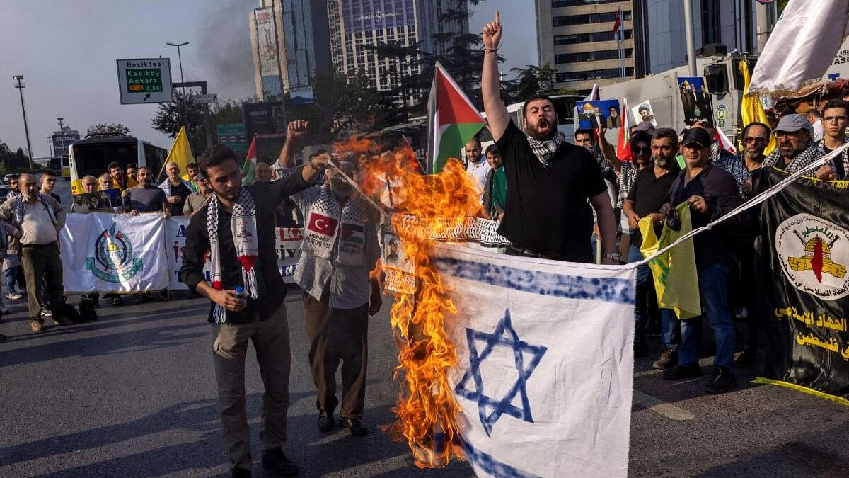 <div class="paragraphs"><p>Protesters set an Israeli national flag on fire, during a demonstration against Israel following the killing of Lebanon's Hezbollah leader Sayyed Hassan Nasrallah in an Israeli air strike in Beirut, near the Israeli Consulate in Istanbul, Turkey, September 29, 2024.</p></div>