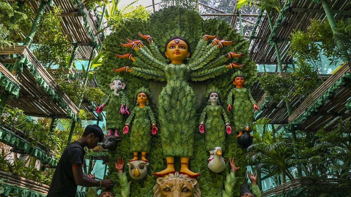 <div class="paragraphs"><p>An artist prepares an 'environment friendly' puja pandal using plants ahead of Durga Puja festival, at Lalabagan Nabankur in Kolkata.</p></div>