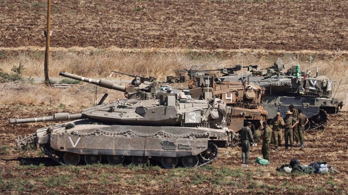 <div class="paragraphs"><p>People stand next to Israeli Army tanks, amid cross-border hostilities between Hezbollah and Israel, in northern Israel.</p></div>