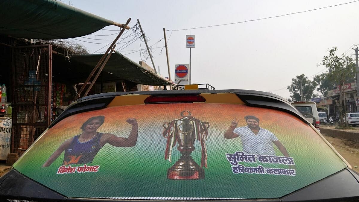 <div class="paragraphs"><p>An election campaign hoarding featuring wrestler turned politician Vinesh Phogat and artist Sumit Kajla, is pasted on back glass of a car during Phogat’s door-to-door election campaign for the upcoming state assembly elections in Julana in the northern state of Haryana.</p></div>