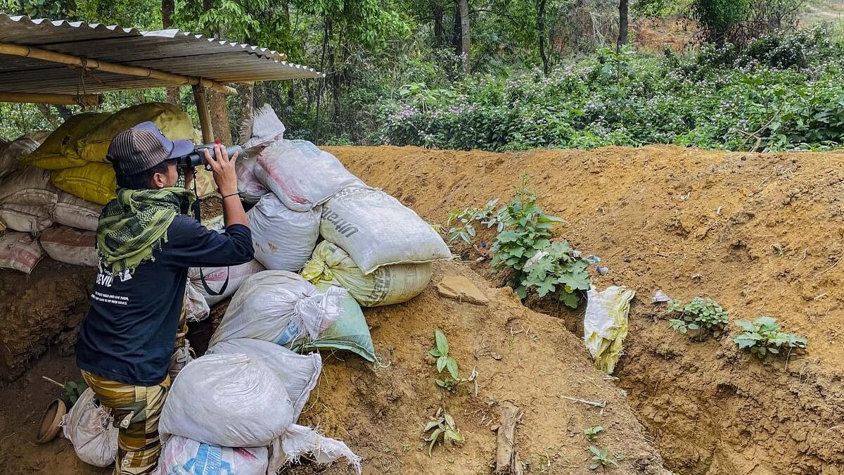 <div class="paragraphs"><p>A 'village volunteer' keeps a watch at a bunker set up in conflict-hit Manipur.</p></div>