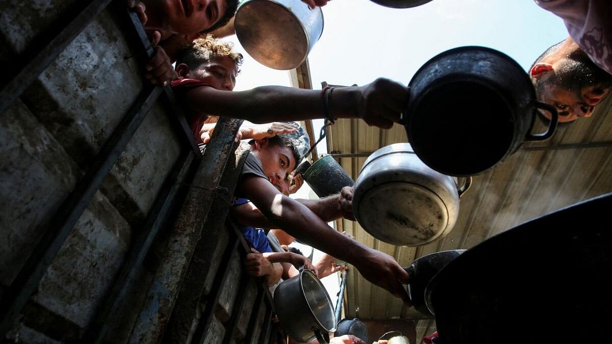 <div class="paragraphs"><p>Palestinians gather to receive food cooked by a charity kitchen, amid the Israel-Hamas conflict, in Khan Younis, southern Gaza Strip.&nbsp;</p></div>