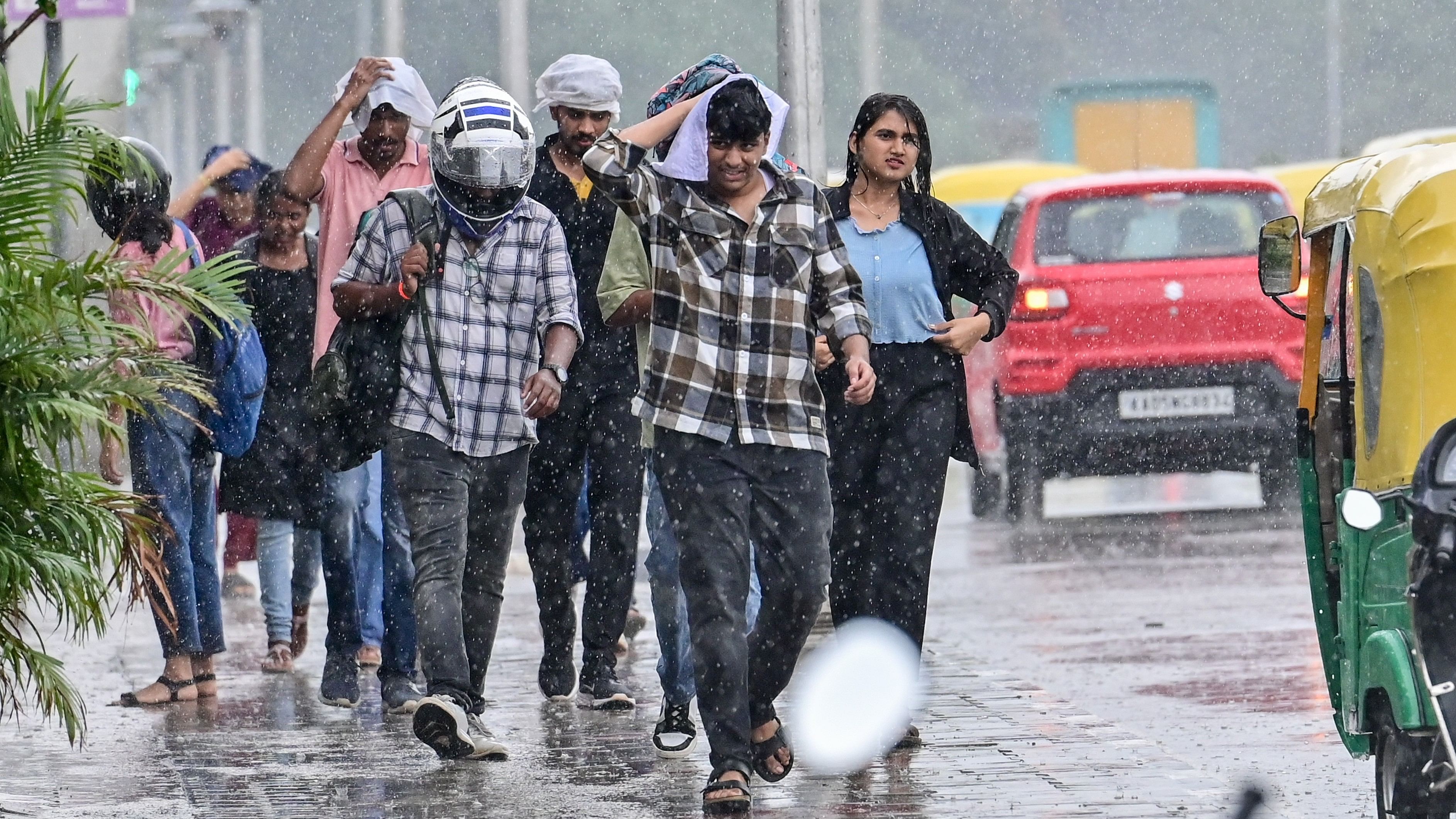 <div class="paragraphs"><p>People, caught unawares by the sudden spell of rain, near Vidhana Soudha on Thursday. </p></div>