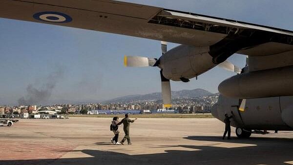 <div class="paragraphs"><p>Smoke rises from Beirut's southern suburbs as a crew member helps two women and a baby to board a Hellenic Air Force C130 during the evacuation of Greek and Greek Cypriot nationals from Lebanon, due to ongoing hostilities between Hezbollah and the Israeli forces, in Beirut, Lebanon, October 3, 2024. </p></div>