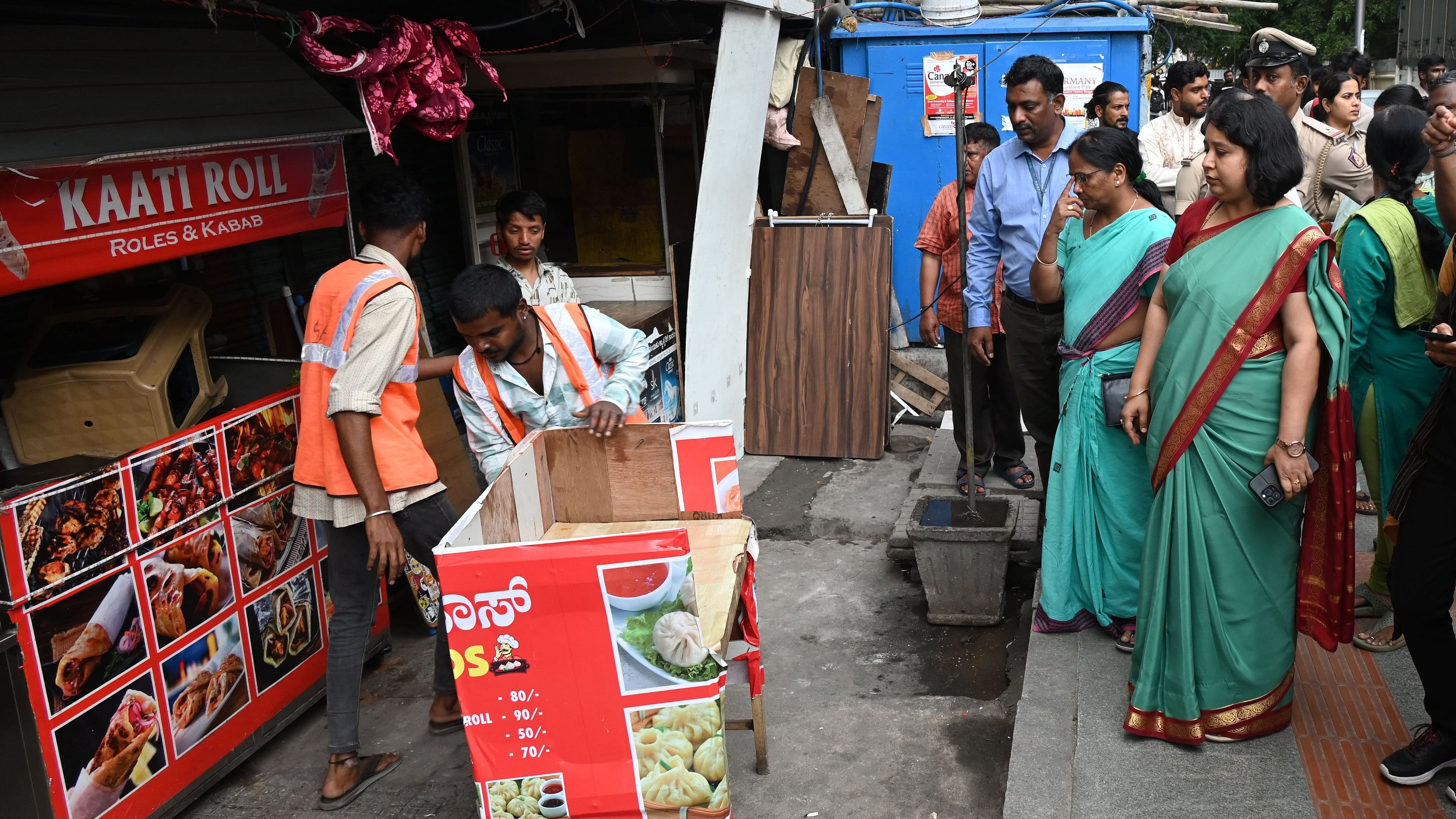 <div class="paragraphs"><p>Workers dismantle a chaat stall on Church Street on Friday. Snehal R, BBMP’s East Zone Commissioner, supervises the work. </p></div>