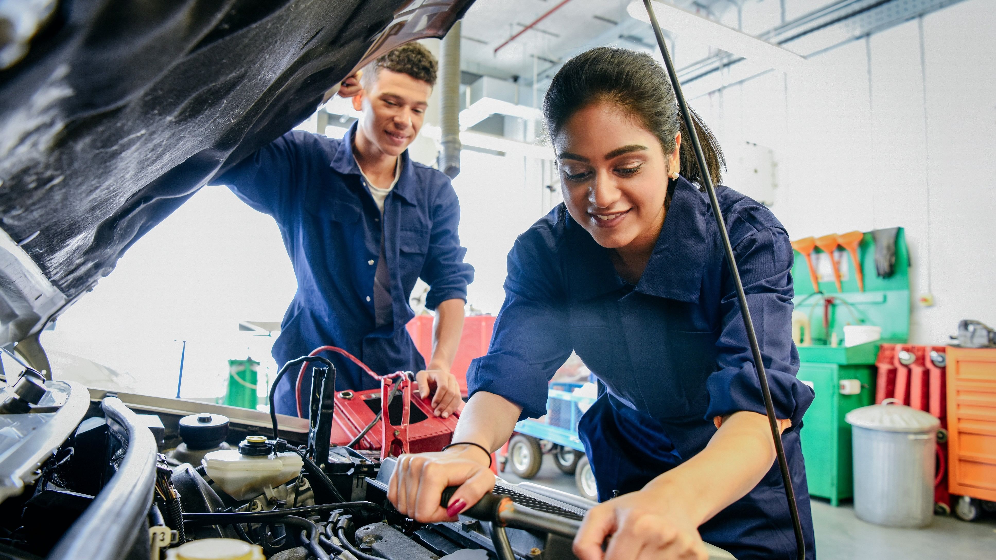 <div class="paragraphs"><p>Two car mechanic students working in garage at FE college, young woman learning mechanical skills Internship. </p></div>