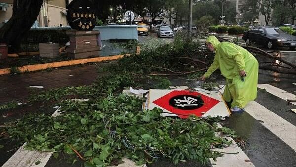 <div class="paragraphs"><p>A man picks up fallen store signs after Typhoon Krathon made landfall in Kaohsiung, Taiwan October 3, 2024. </p></div>