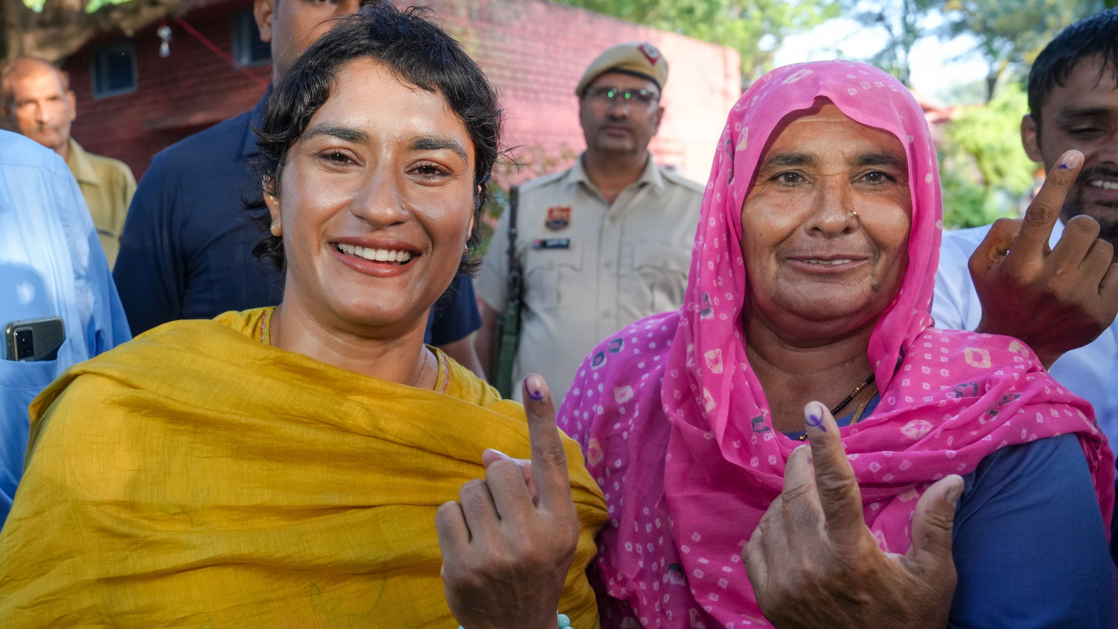 <div class="paragraphs"><p>Congress candidate from Julana constituency Vinesh Phogat and her mother show their fingers marked with indelible ink after casting their votes at a polling station at Balali village during the Haryana Assembly elections, in Charkhi Dadri district, Saturday, Oct. 5, 2024.</p></div>