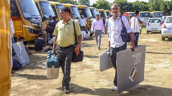 <div class="paragraphs"><p>Polling officials carry EVM and other election material as they leave for their respective polling stations on the eve of the Haryana Assembly elections, in Rohtak, Haryana, Friday, Oct 4, 2024.</p></div>