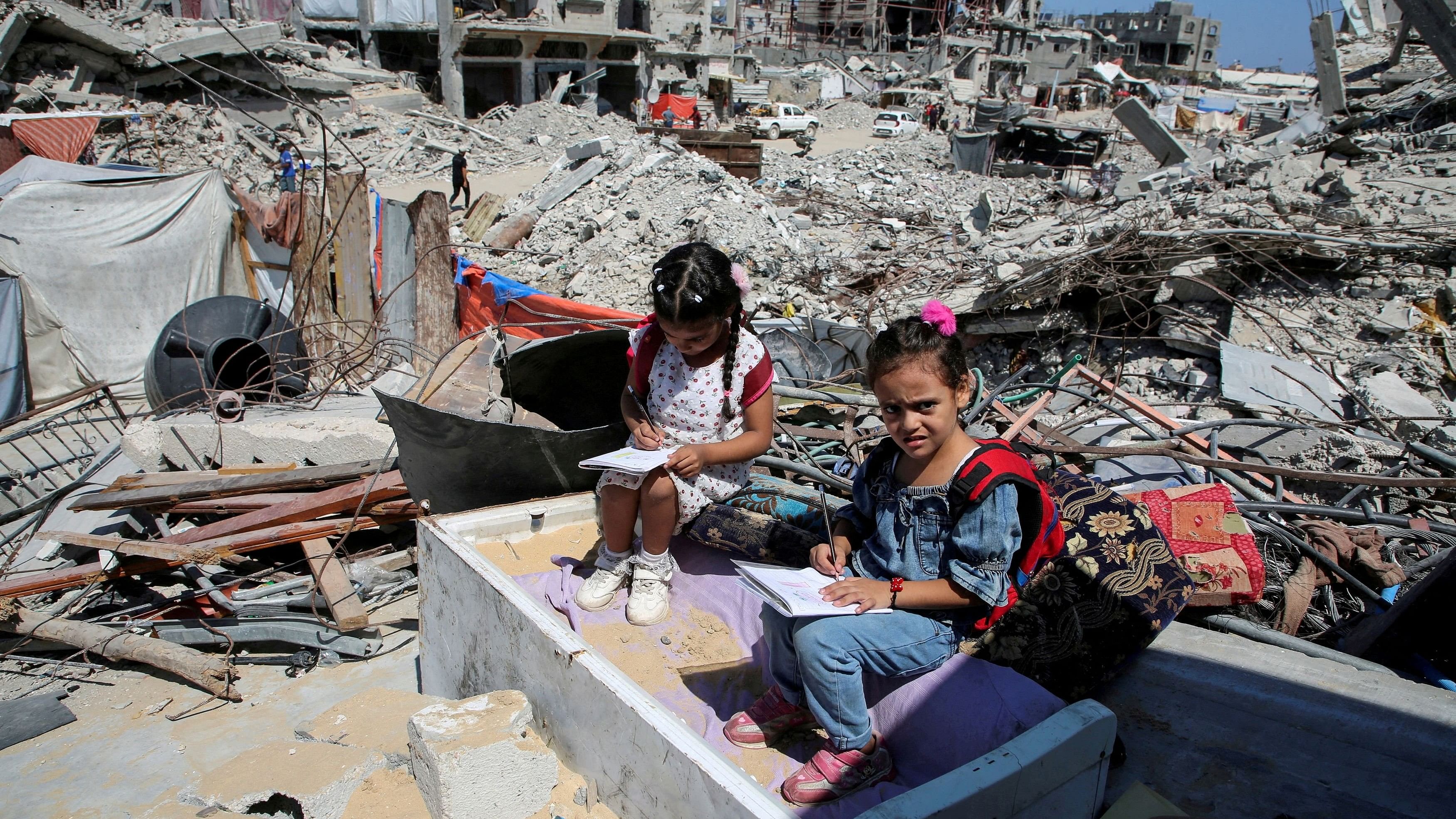 FILE PHOTO: Palestinian students sit on the rubble after attending a class in a tent set up on the ruins of the house of teacher Israa Abu Mustafa, as war disrupts a new school year, amid the Israel-Hamas conflict, in Khan Younis, in the southern Gaza Strip, September 4, 2024. REUTERS/Hatem Khaled/File Photo/File Photo