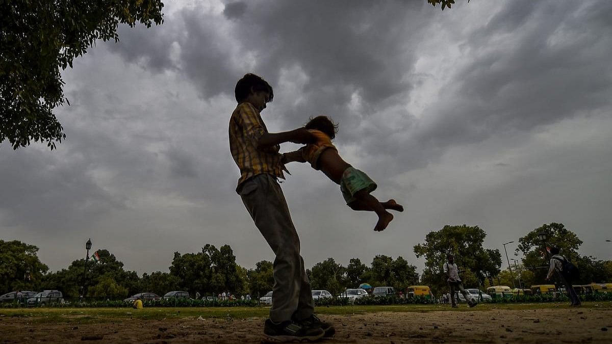 <div class="paragraphs"><p>A young boy plays with a child as monsoon clouds gather in New Delhi</p></div>