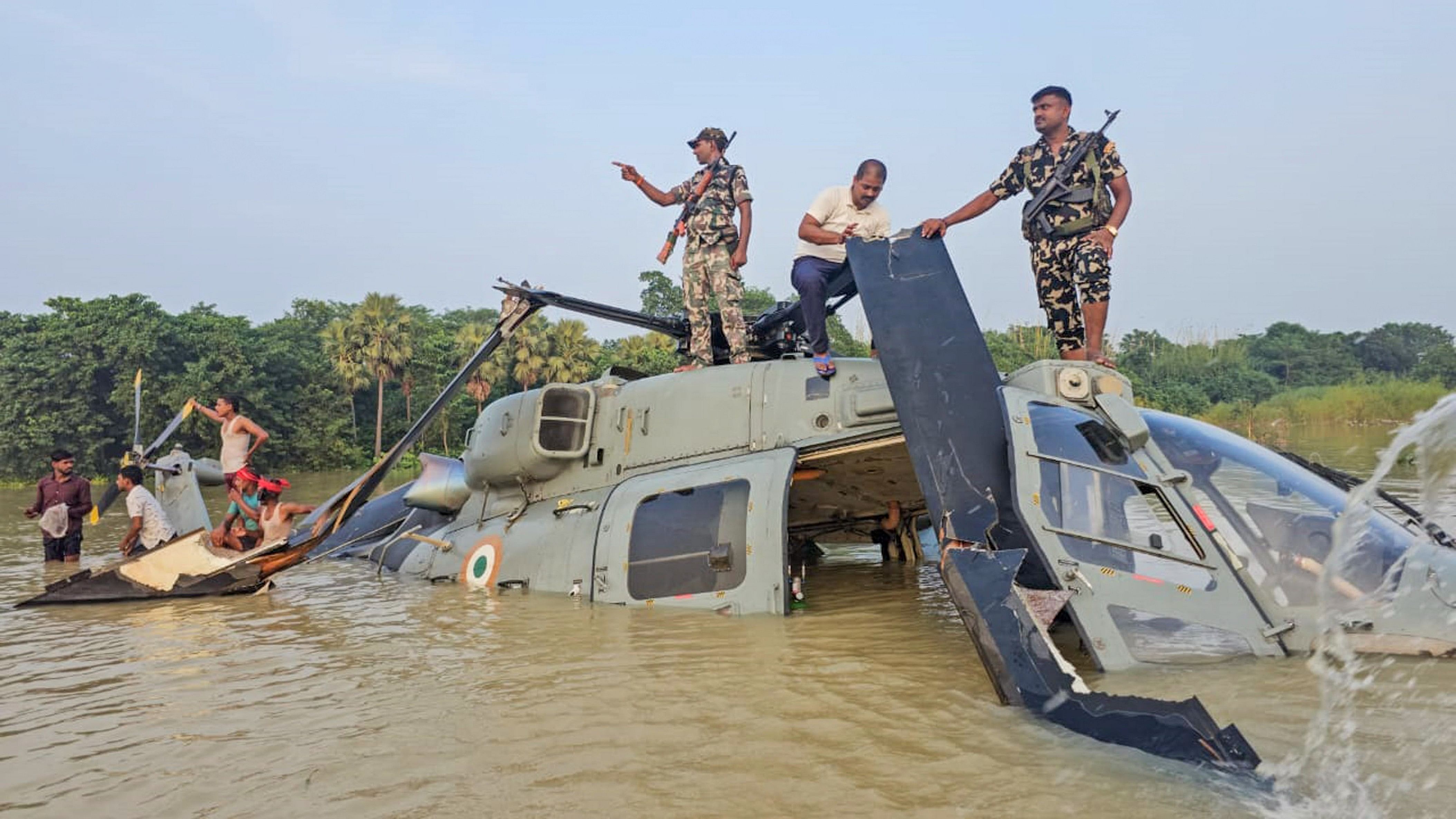 <div class="paragraphs"><p>Security personnel keep vigil after an Indian Air Force helicopter on flood relief duty made an emergency landing in a waterlogged area upon developing a snag, in Bihar's Muzaffarpur district on Wednesday.</p></div>