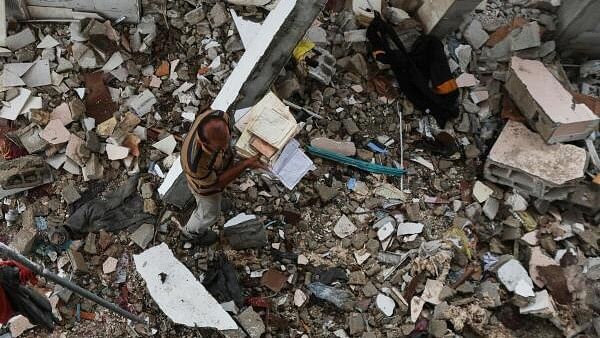 <div class="paragraphs"><p>A Palestinian collects copies of the Koran at the site of an Israeli strike on a mosque sheltering displaced people, amid Israel-Hamas conflict, in Deir Al-Balah, in the central Gaza Strip.&nbsp;</p></div>