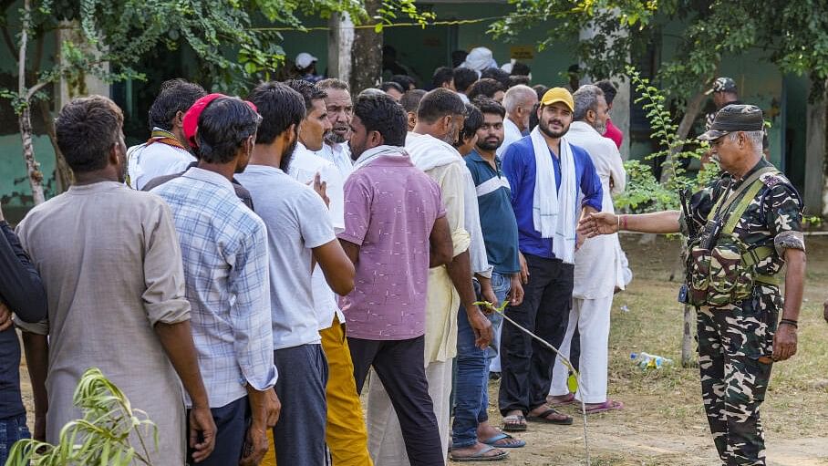 <div class="paragraphs"><p>Security personnel keep a watch on voters lining up to cast their votes after clashes during Haryana Assembly polls.&nbsp;</p></div>