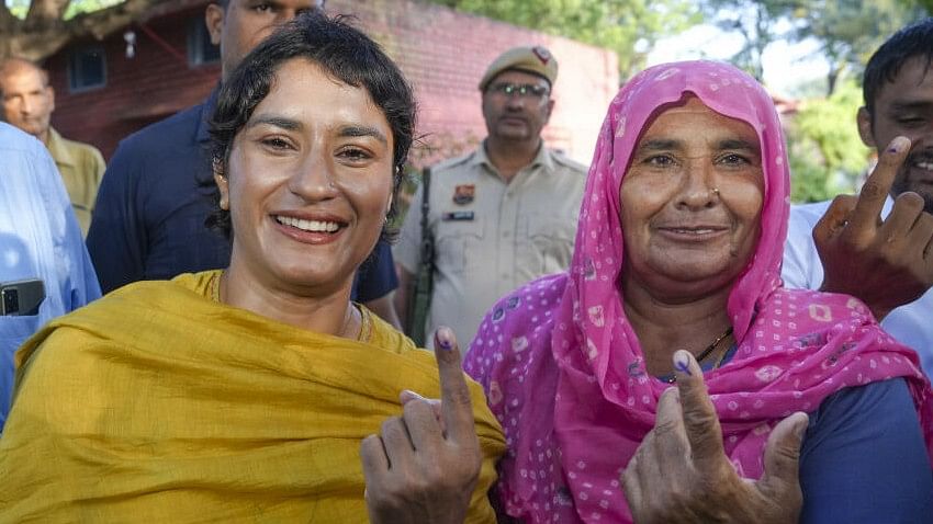 <div class="paragraphs"><p>Vinesh Phogat and her mother show their fingers marked with indelible ink after casting their votes at a polling station at Balali village during the Haryana Assembly elections.</p></div>