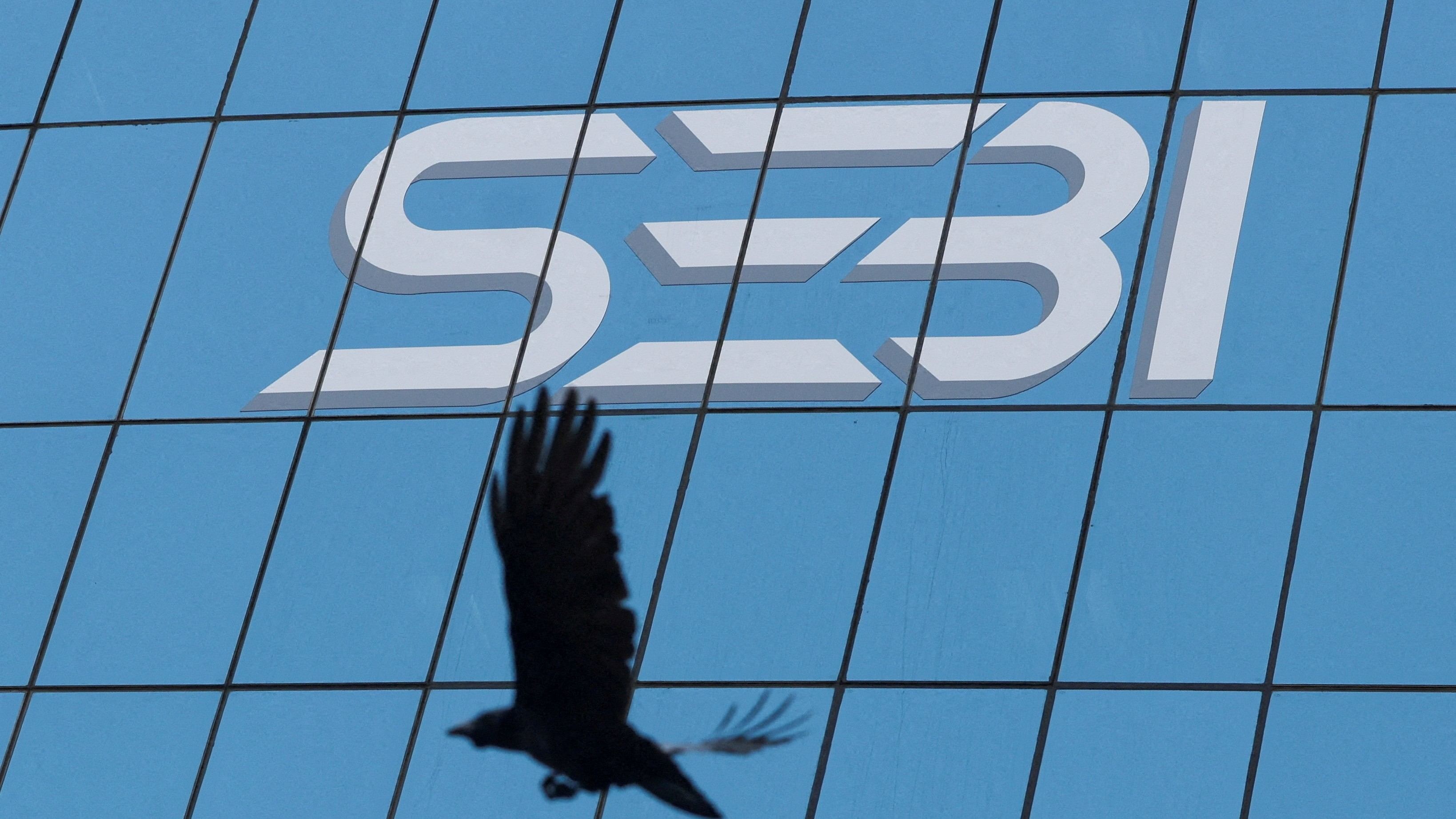 <div class="paragraphs"><p>A bird flies past the logo of the Securities and Exchange Board of India (SEBI) at its headquarters in Mumbai, India</p></div>