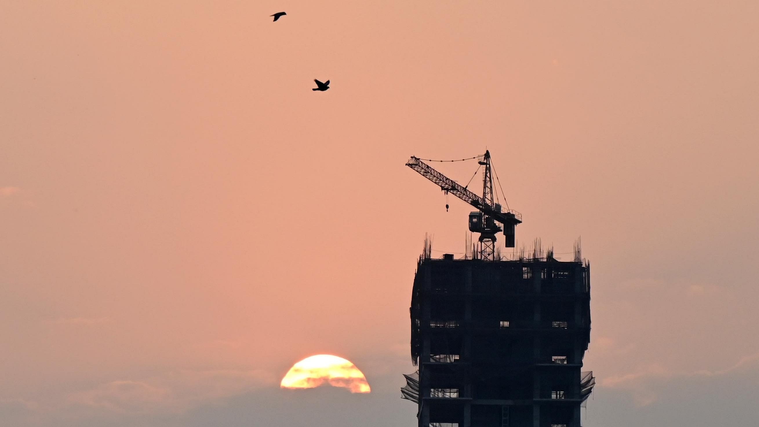 <div class="paragraphs"><p>A sunset through a construction building near Cantonment railway station in Bengaluru on Monday. </p></div>