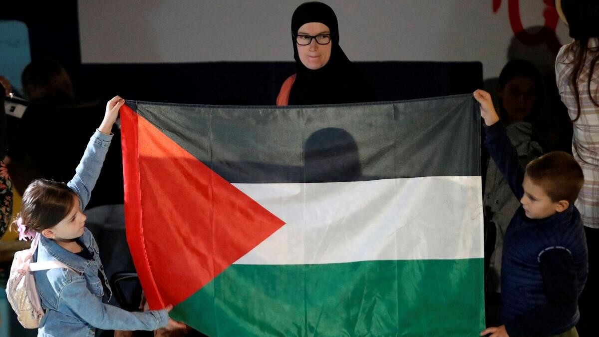 <div class="paragraphs"><p>A woman looks at children holding a Palestine flag as Palestinian support groups mark the first anniversary of the Gaza war, in Podgorica, Montenegro, October 8, 2024.</p></div>