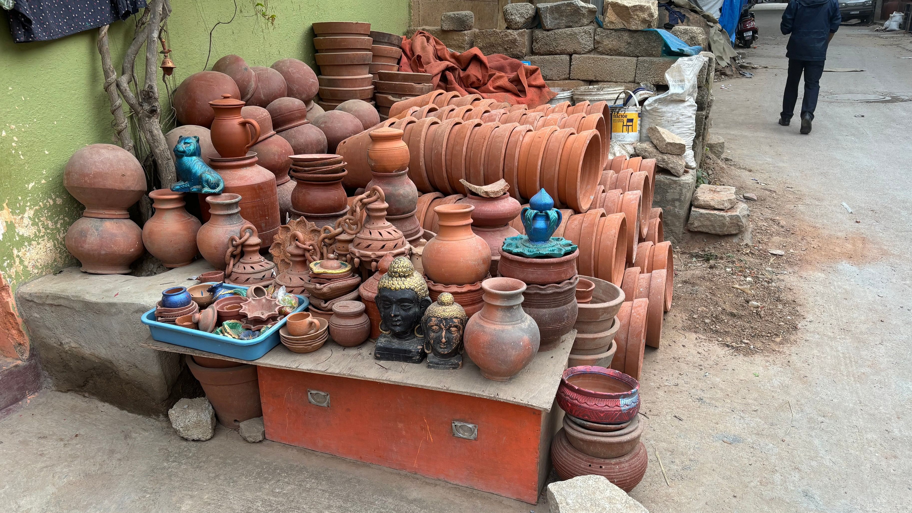 <div class="paragraphs"><p>A potter at the wheel; a display of finished products at Pottery Town in Bengaluru. </p></div>