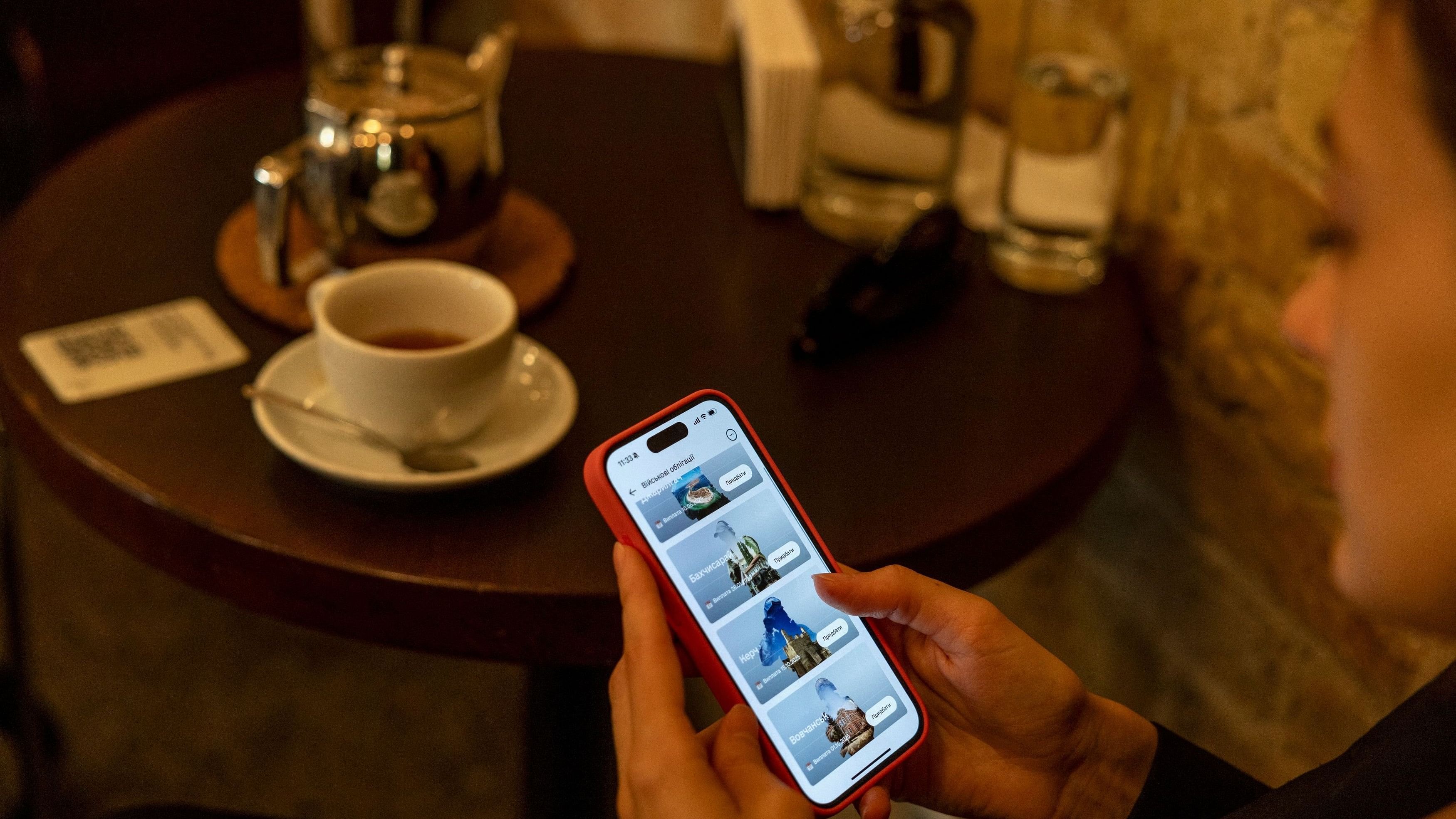 <div class="paragraphs"><p>Lawyer Olesia Mykhailenko shows the app on her phone where she purchased Ukrainian war bonds in a cafe in Kyiv, amid Russia's attack on Ukraine, October 9, 2024. </p></div>