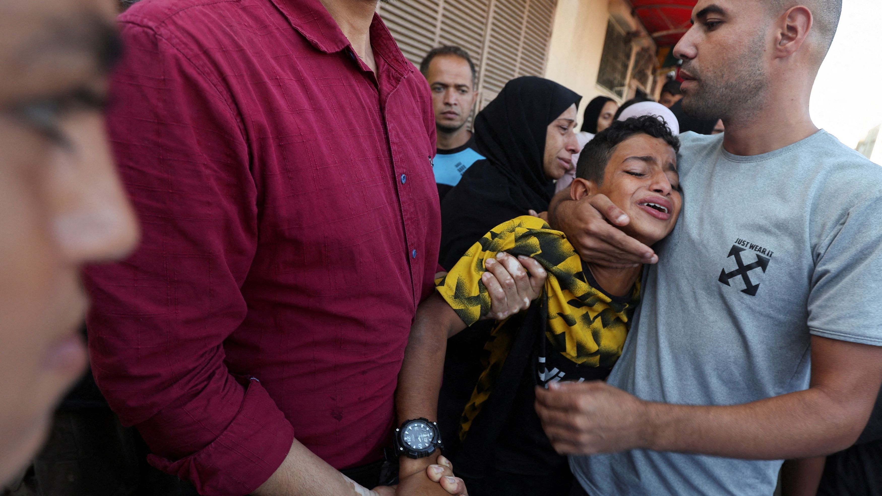 <div class="paragraphs"><p>A boy is comforted as he mourns near the body of his father and other Palestinians, who were killed in an Israeli strike, amid the Israel-Hamas conflict, at Al-Aqsa Martyrs Hospital in Deir Al-Balah in the central Gaza Strip, October 9, 2024.</p></div>