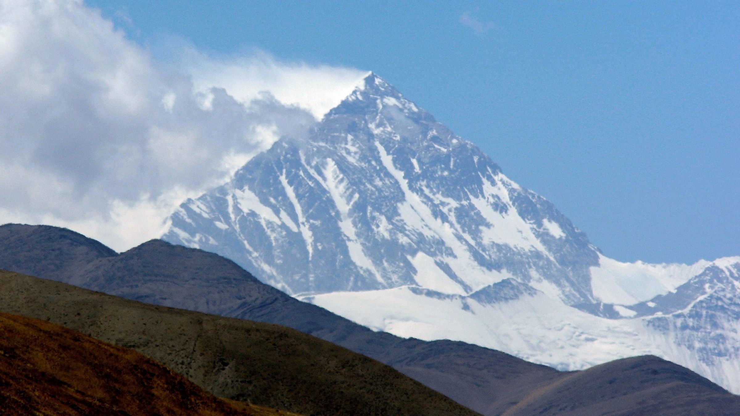 <div class="paragraphs"><p>FILE PHOTO: Mount Everest, known in Tibetan as Qomolangma, rises behind foothills, as seen from near the Tibetan town of Shegar.</p></div>