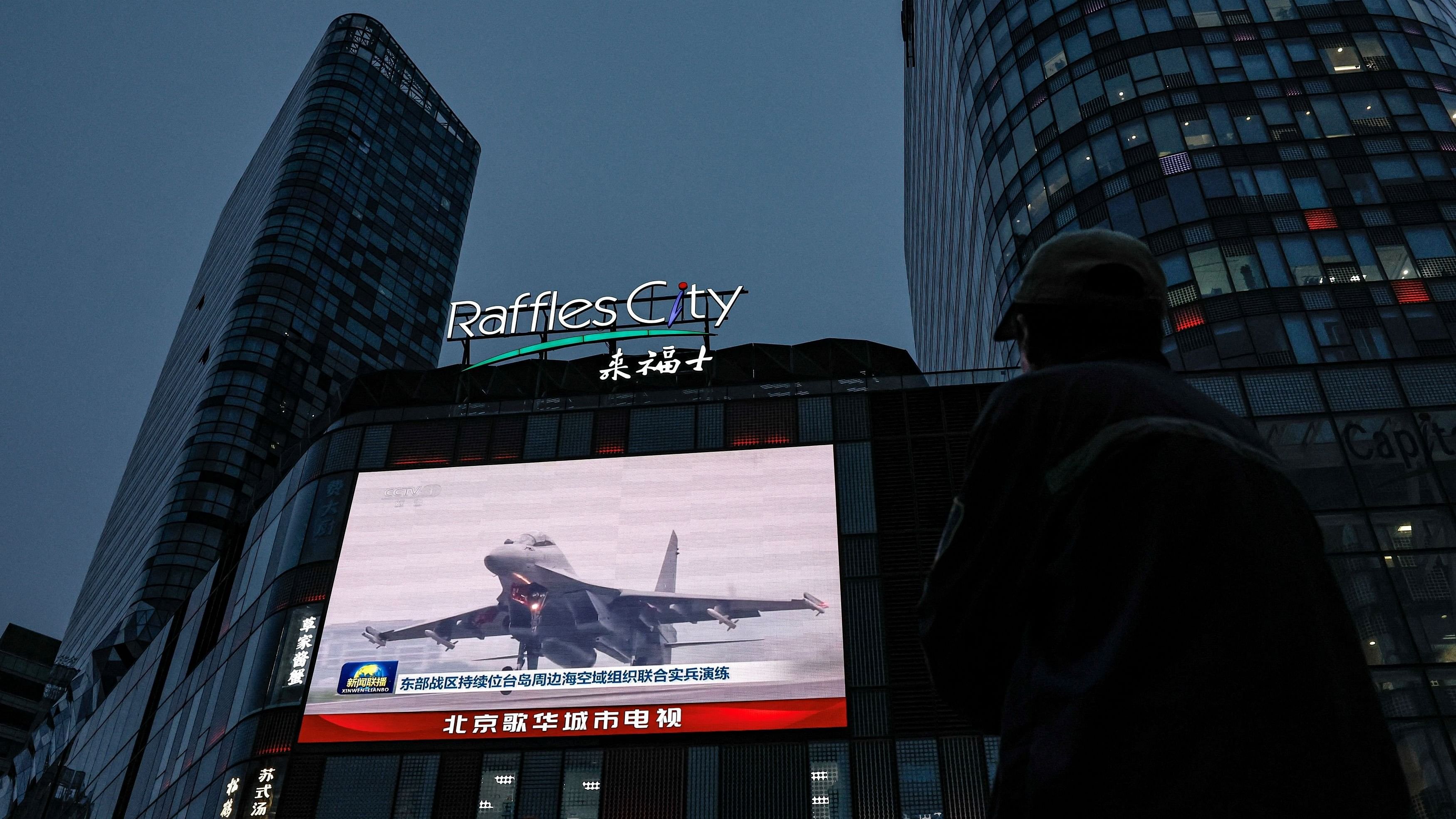 <div class="paragraphs"><p>A man looks at a giant screen showing news footage of military drills conducted in areas around the island of Taiwan by the Eastern Theatre Command of the Chinese People's Liberation Army, in Beijing, China.</p></div>