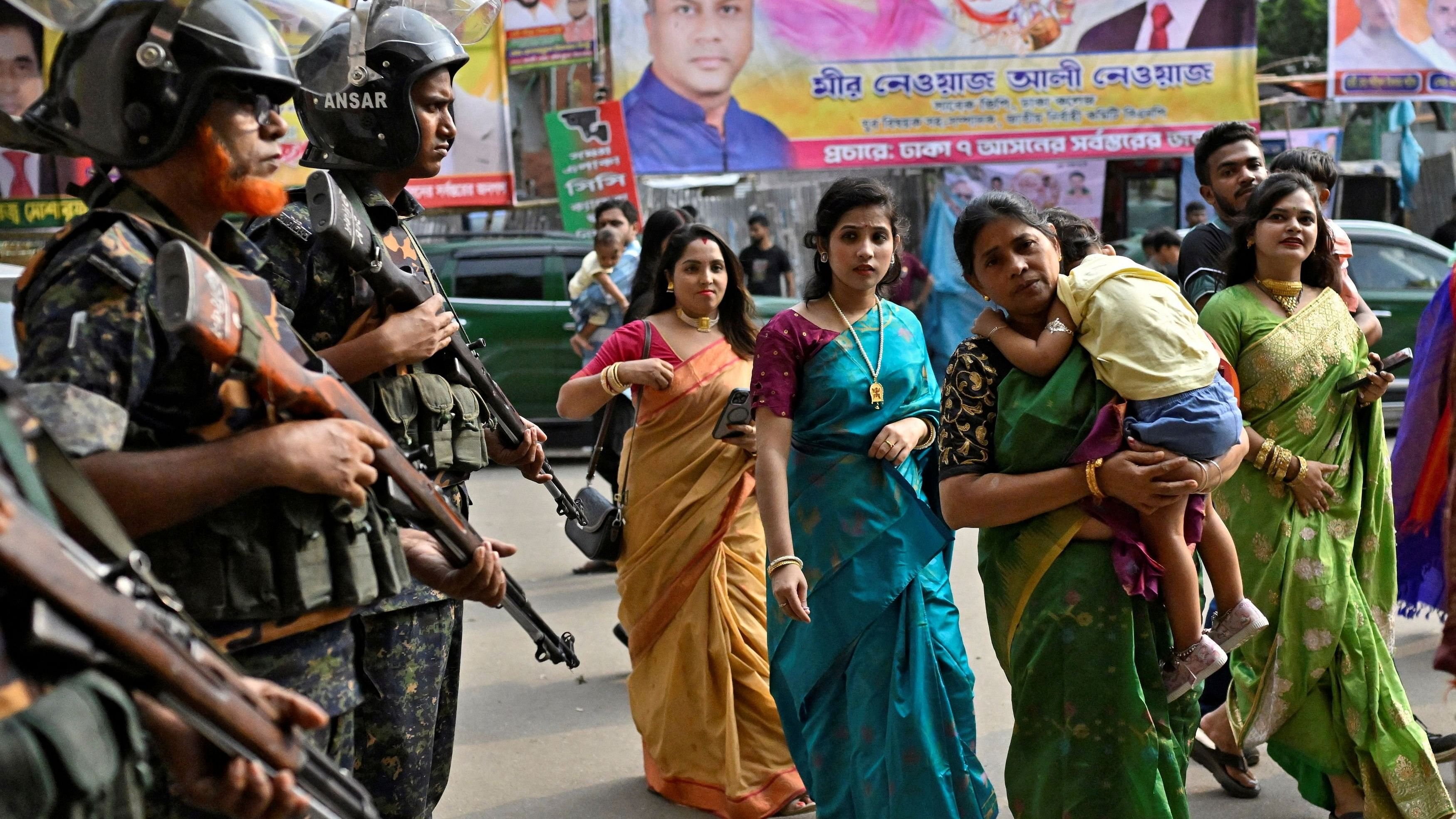 <div class="paragraphs"><p>Security force personnel stand guard as Hindu devotees arrive to offer prayers Durga Puja festival, outside a temple in Dhaka, Bangladesh.</p></div>