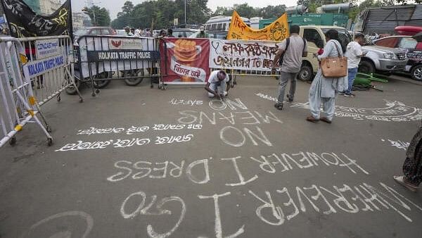 <div class="paragraphs"><p>An agitator paints slogans on a road at the site of the hunger strike by junior doctors in protest against the alleged sexual assault and murder of a trainee doctor, in Kolkata, West Bengal, Sunday, Oct. 13, 2024.</p></div>