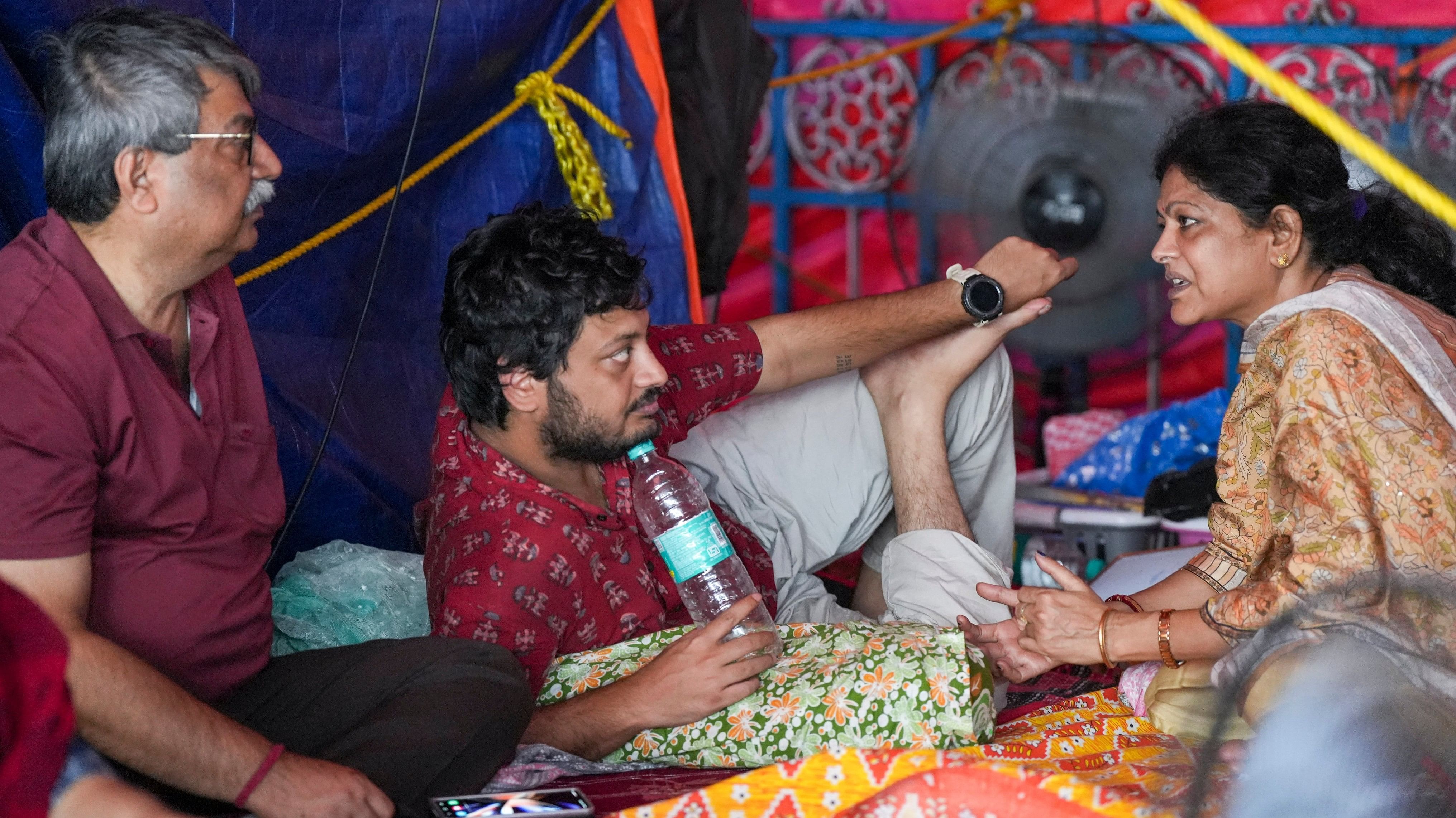 <div class="paragraphs"><p>A junior doctor, centre, with others during a hunger strike in protest against the alleged sexual assault and murder of a trainee doctor, in Kolkata, West Bengal.</p></div>