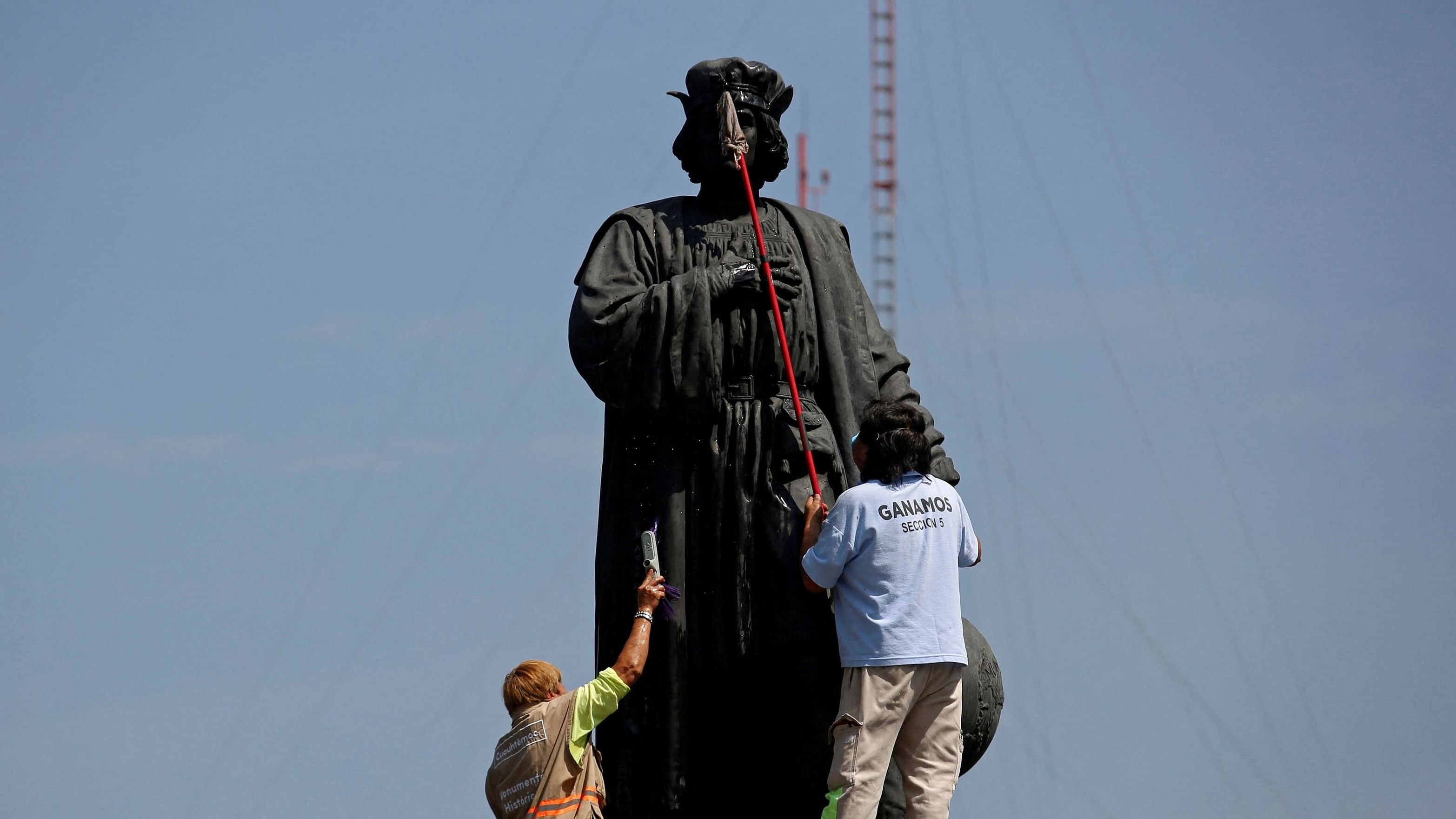 <div class="paragraphs"><p>Workers clean the statue Christopher Columbus.&nbsp;</p></div>