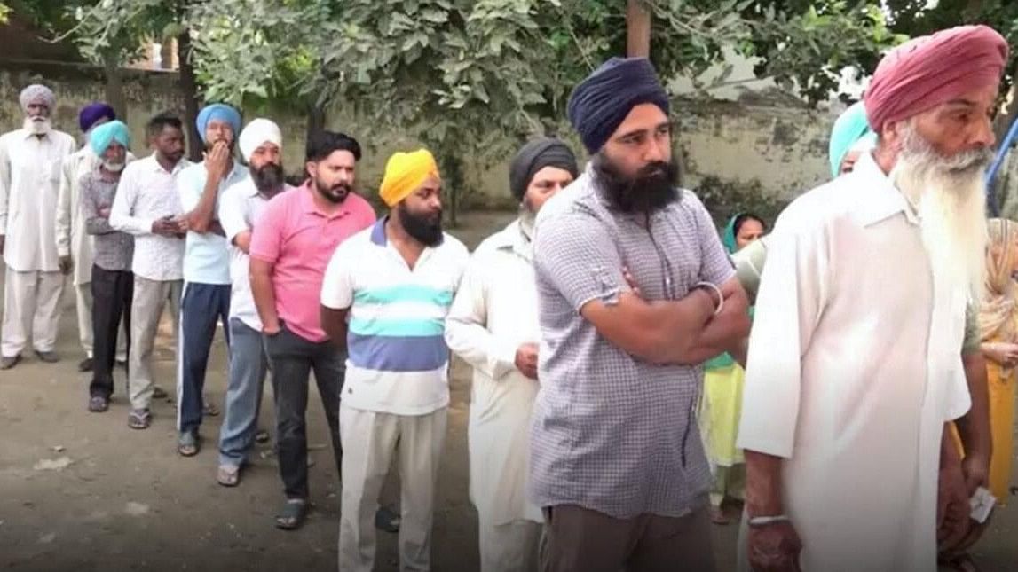 <div class="paragraphs"><p>People&nbsp;wait to cast their votes for the Punjab Gram-Panchayat elections.</p></div>