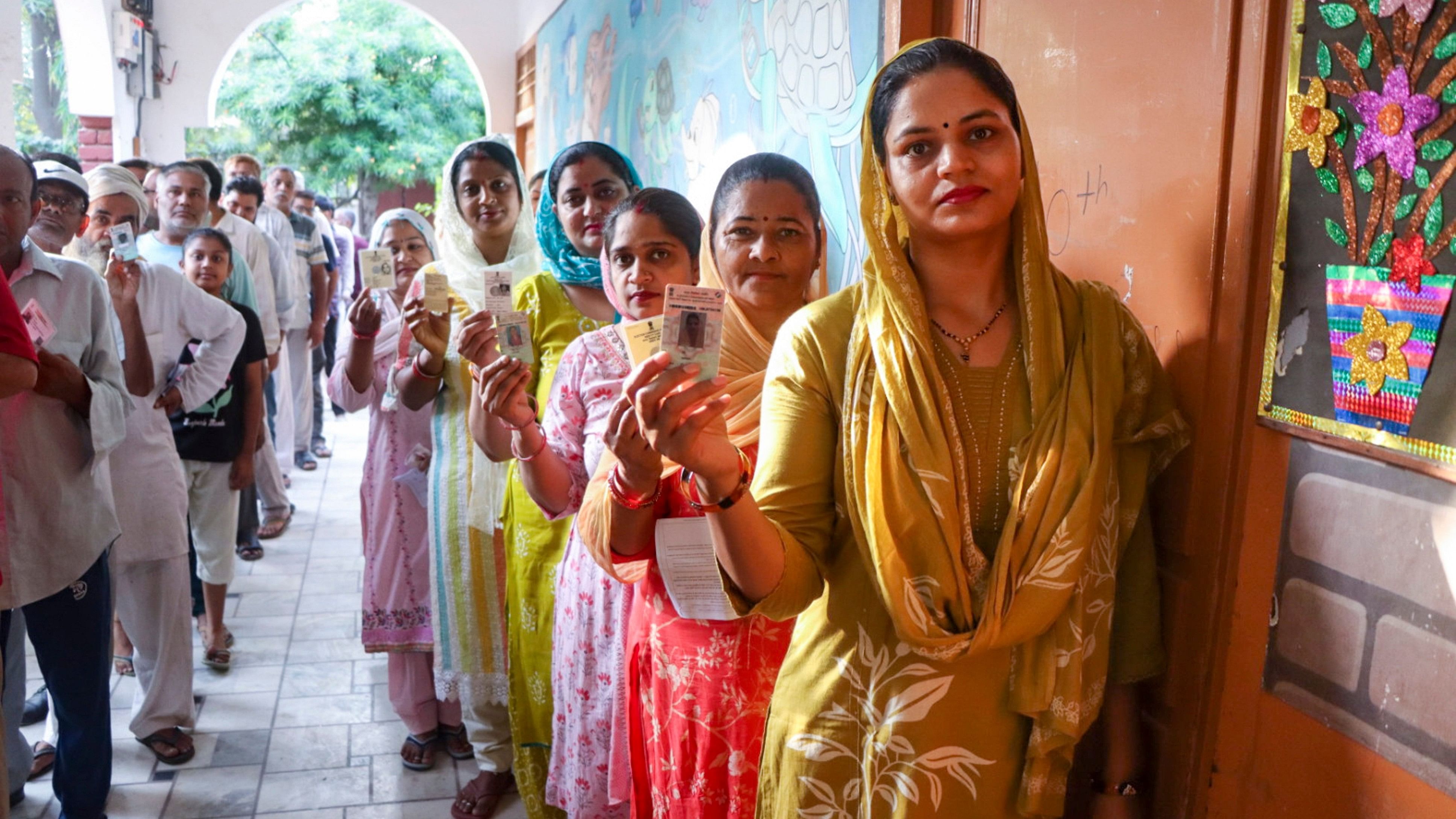 <div class="paragraphs"><p>Voters wait in a queue to cast their votes at a polling station during the Haryana Assembly elections, in Rohtak district.</p></div>