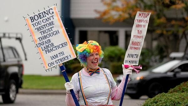 <div class="paragraphs"><p>A Boeing worker from the International Association of Machinists and Aerospace Workers District 751 holds signs during an ongoing strike in Seattle, Washington.</p></div>