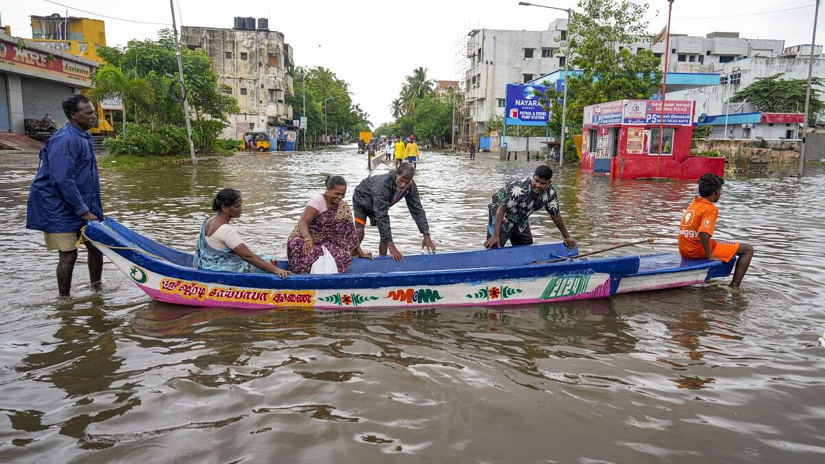 <div class="paragraphs"><p>People use a boat to go to a safer place on a waterlogged road amid rains, in Chennai.</p></div>