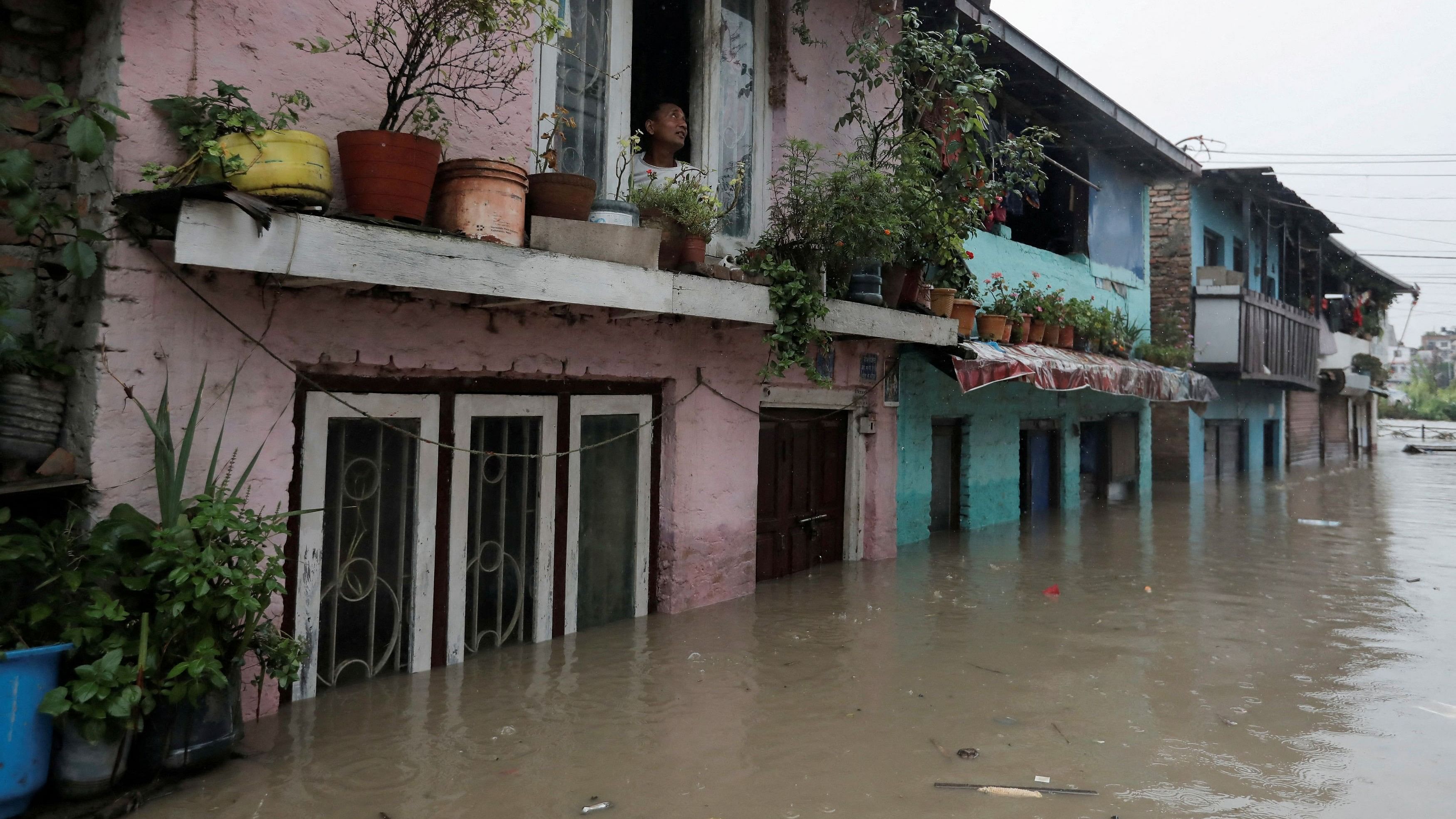 <div class="paragraphs"><p>A man looks out from the window of his house in an area flooded by the overflowing Bagmati river following heavy rains, in Kathmandu, Nepal August 8, 2023.</p></div>